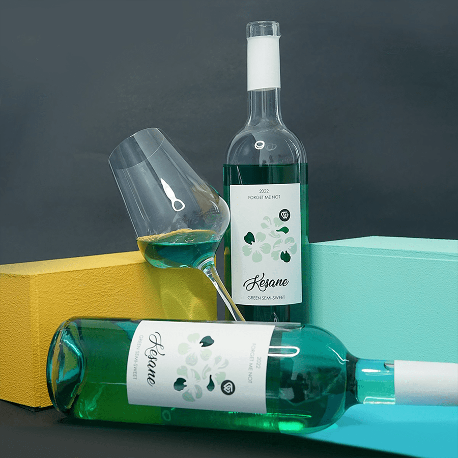 Kesane Green - KISI - zelený vinný nápoj - 2021 - 0,75 l Kesane green je zelený vinný alkoholový nápoj vyrobený z kvevri vína Kisi. Tento polosladký nápoj se pyšní nenapodobitelným aromatem a chutí, podpořenou zráním v tradičních kvevri nádobách. V jeho chuťovém profilu najdete tóny lískových oříšků, meruněk, broskví a jablek. Ideální je jako doplněk k lehkým dezertům, ovocným salátům či jemným sýrům. Tento jedinečný nápoj vás okouzlí svou vyváženou sladkostí a bohatým aroma. Gruzínské polosladké zelené víno Kesane s květinovým designem etikety a sklenkou na víno na barevném pozadí